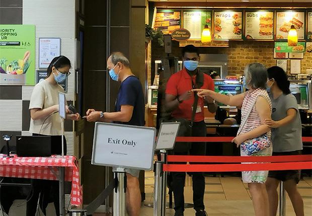 スーパーマーケットでは、政府が開発した訪問者登録システム「セーフエントリー」を使い、来店者のＩＤカードを読み取るなどして入店を記録している＝シンガポール東部（ＮＮＡ撮影）