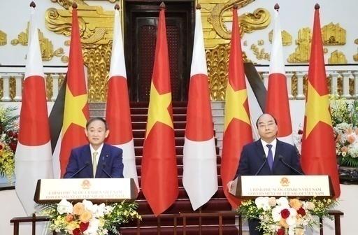 菅首相（左）とフック首相が19日に首脳会談を実施し、供給網の再編などで協力を強化する方針を確認した＝ハノイ（共同通信）