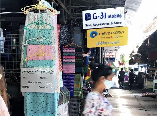 「ウェーブ・マネー取扱店」の看板が掲げられたミャンマーの市場＝５月、ヤンゴン（ＮＮＡ）