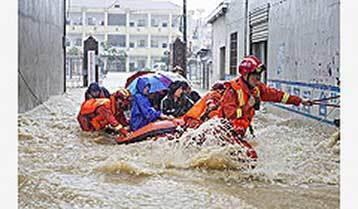 洪水の中、学生を移送する救助隊＝７月８日、江西省九江市（新華社）