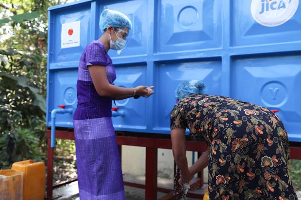 ＪＩＣＡが提供した貯水タンクで手を洗うミャンマーの女性＝11日、ヤンゴン管区（ＪＩＣＡ提供）