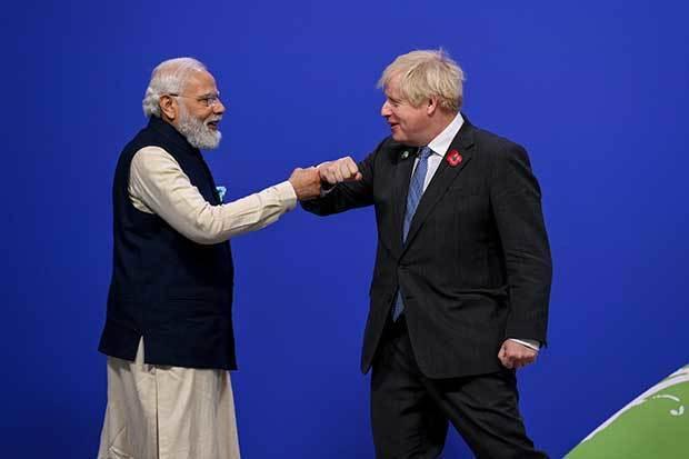 国連気候変動枠組み条約第26回締約国会議（ＣＯＰ26）の首脳級会合で、開催国の英国のジョンソン首相（右）と拳を付き合わせてあいさつするインドのモディ首相＝１日、英国・グラスゴー（同国政府提供）