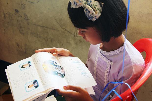 ダルニー奨学金の支援者からの手紙を読む子ども＝11月15日、ミャンマー・ヤンゴン（ＮＮＡ）