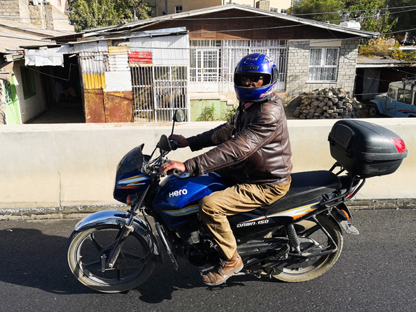ヒーローの小型バイクに乗る男性