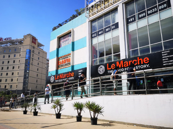 3月27日、グルガオンにある大型スーパーの店先で間隔を空けて入店を待つ人の列