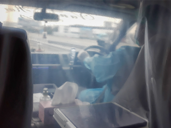 空港からホテルに向かうバンの運転席と乗客の間は、ビニールシートで仕切られていた＝８月７日（ＮＮＡ撮影）