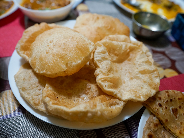 北インド家庭料理の定番、揚げパンの「プーリー」。できたてを台所から運ぶ
