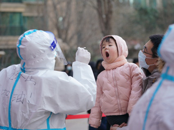 中国では１月に入り華北・東北地域で新型コロナウイルスの感染者が拡大。河北省の省都・石家荘市では全市民を対象に一斉スクリーニングを展開し、幼い子どももＰＣＲ検査の検体採取に臨んだ＝１月６日、河北省石家荘市（新華社）