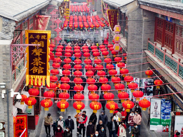 通りは春節（旧正月）を祝う赤い提灯で彩られ、帰省した人々でにぎわう＝2021年２月13日、中国・天津市（新華社）