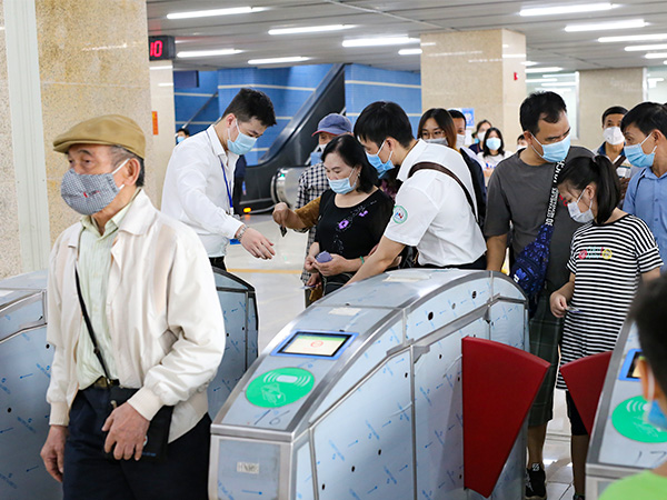 改札を通過する人々＝21年11月、ベトナム・ハノイ市カットリン駅