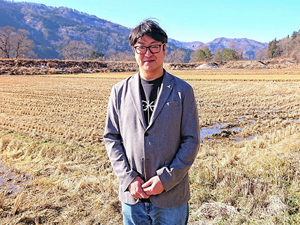 「酒造りを通じ、只見の田んぼを守りたい」と話す、ねっか代表社員の脇坂斉弘さん=21年12月9日、只見町の自社田(NNA撮影)