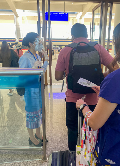 ビエンチャン駅で乗客のチケットを確認する民族衣装姿のスタッフ＝8月28日（筆者提供）