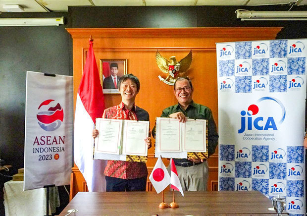 文書に署名したＪＩＣＡインドネシア事務所の岡村次長（左）と環境・林業省気候変動管理局のアグス局長代行＝22日（ＪＩＣＡ提供）