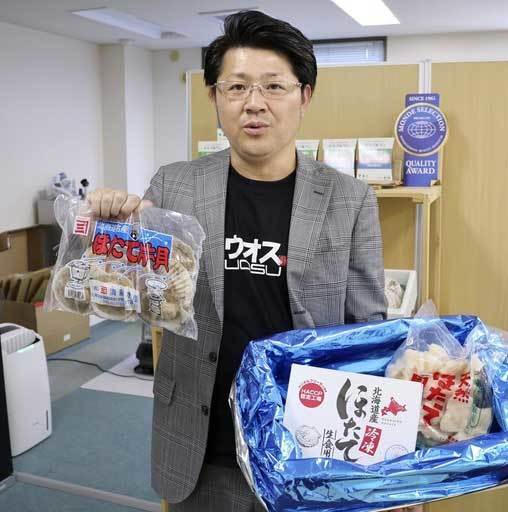 国内向けに販売しているホタテ商品を手にする水産物卸「進風」の山田英司事業推進課長＝16日、札幌市（共同）