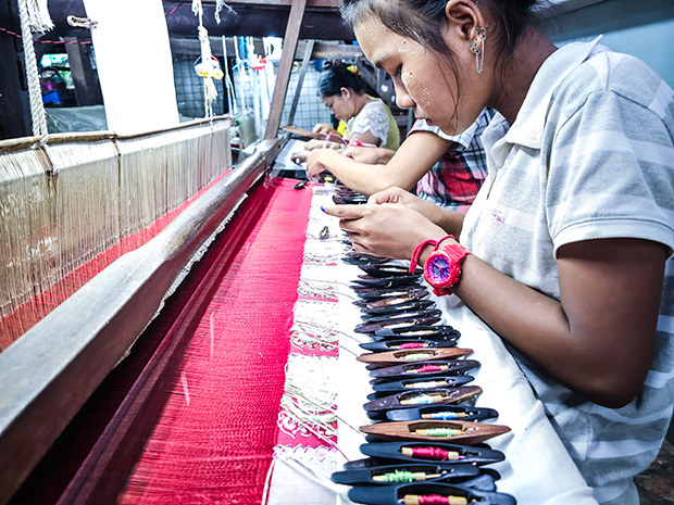 横糸を通すシャトルを複数使用する「ルンタヤ・アチェイク」を織る職人＝11日、ミャンマー・アマラプラ（ＮＮＡ）