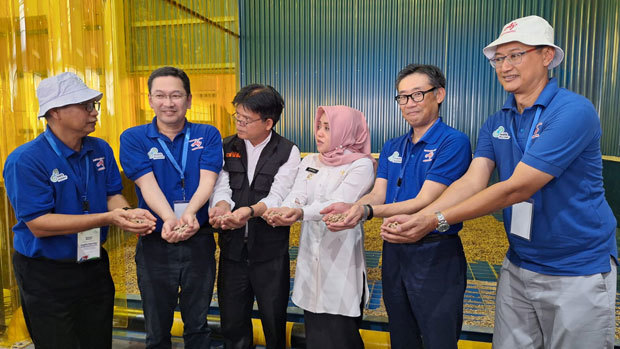 バイオマスボイラーで使用するバイオマス燃料を紹介するインドネシア味の素の松本社長（右から２人目）ら関係者＝１日、東ジャワ州モジョケルト（ＮＮＡ撮影）