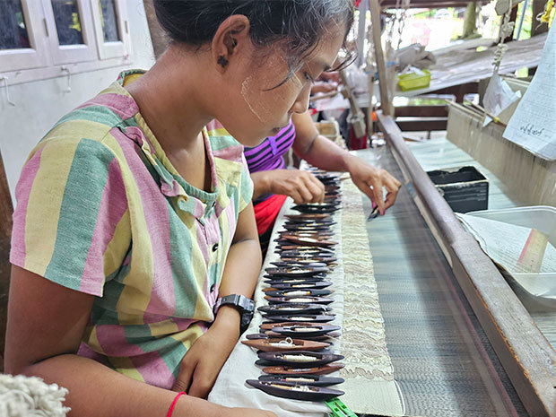 横糸を通すシャトルを複数使用し、絹織物を手作業で織る職人＝９月、ミャンマー・マンダレー市郊外のアマラプラ（ＮＮＡ）