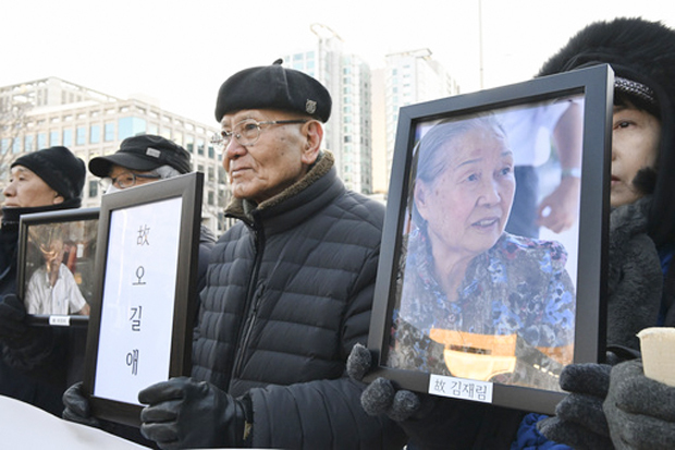ソウルの韓国最高裁前で遺影を掲げる韓国人元徴用工や元朝鮮女子勤労挺身隊員の訴訟の原告遺族ら＝2023年12月21日（共同）