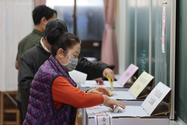 台北市の投票所で投票する有権者＝13日（中央通信社）
