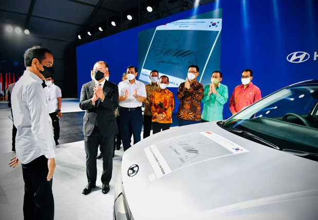 初の現地生産ＥＶとなった現代自動車の「アイオニック５」の記念式典に出席し、車体にサインをしたジョコ大統領（左端）＝22年３月、西ジャワ州（大統領府提供）