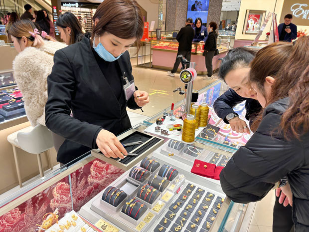 若者の金宝飾品人気が高まっている。今年は金のチャームをつけたブレスレットが人気だ＝上海市