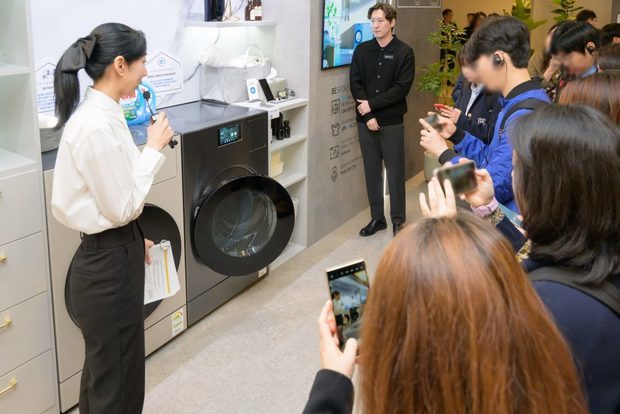 サムスン電子のスタッフが洗濯機と乾燥機がセットになった「ビスポークＡＩコンボ」の機能を説明している＝韓国（同社提供）