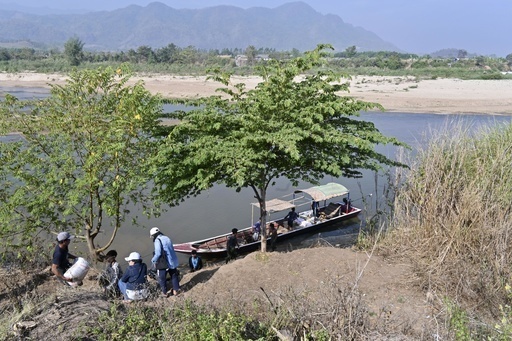 タイ・メソトで小舟にミャンマーへの支援物資を積み込む市民＝２月（共同） 