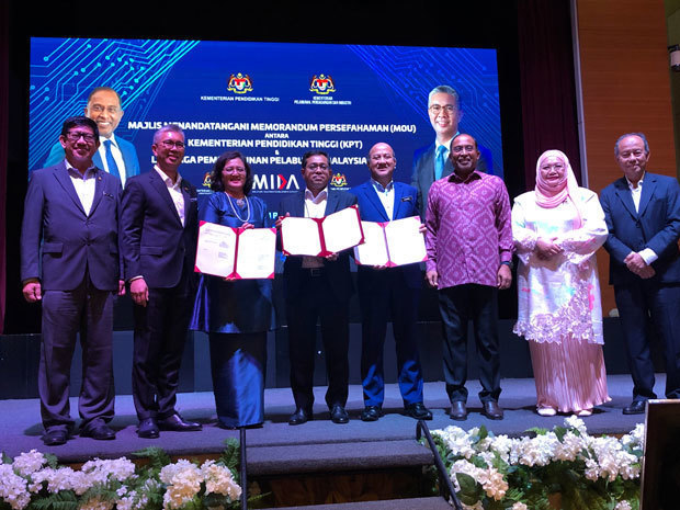 マレーシア投資開発庁と高等教育省の人材育成に関する覚書調印式に出席したザフルル投資貿易産業相（左から２人目）、ザンブリー・アブドル・カディル高等教育相（右から３人目）ら＝７日、クアラルンプール（ＮＮＡ撮影）