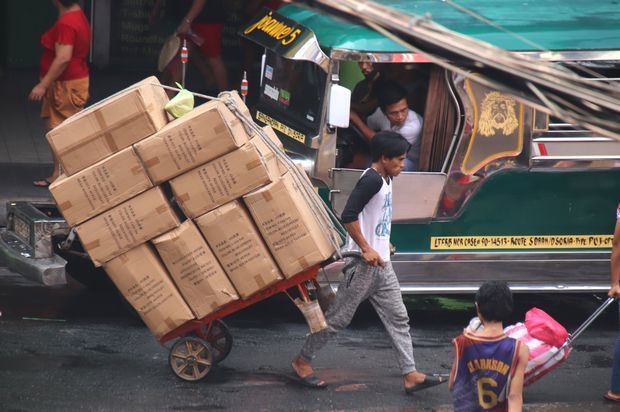 市場で荷物を運ぶ市民ら＝８日、首都マニラ（ＮＮＡ撮影）