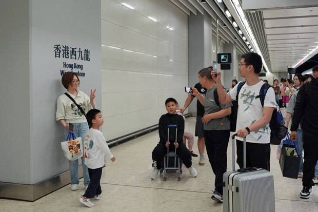 高速鉄道で本土から香港を訪れ、西九龍駅で記念写真を撮る観光客＝１日（新華社）