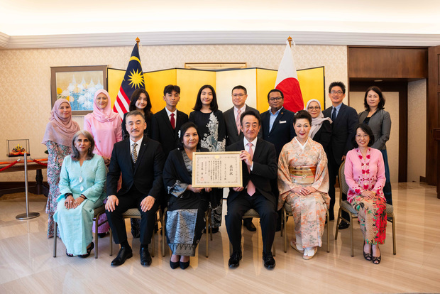 ９日の外務大臣表彰の伝達式で記念撮影する高橋克彦駐マレーシア日本大使（前列右から３人目）とマラヤ大学マレーシア日本研究センターのジャミラ・モハマド・センター長（同４人目）（在マレーシア日本大使館提供）