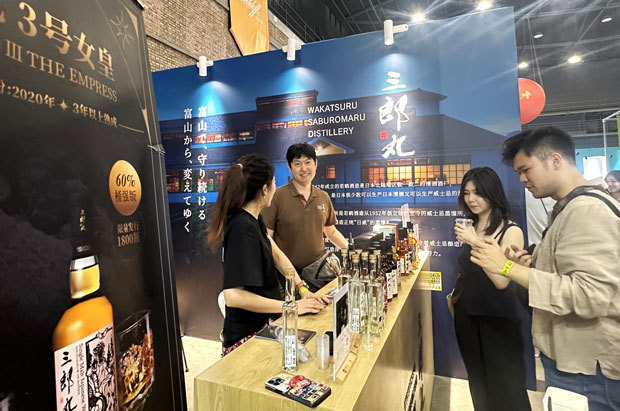 北京市で開かれたイベントで、来場者にウイスキーを振る舞う若鶴酒造の稲垣貴彦ＣＥＯ（左奥）＝17日