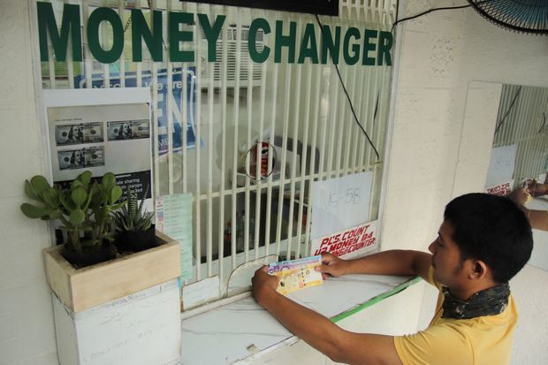 両替所でペソと米ドルを交換する市民＝21日、マニラ首都圏マカティ市（ＮＮＡ撮影）