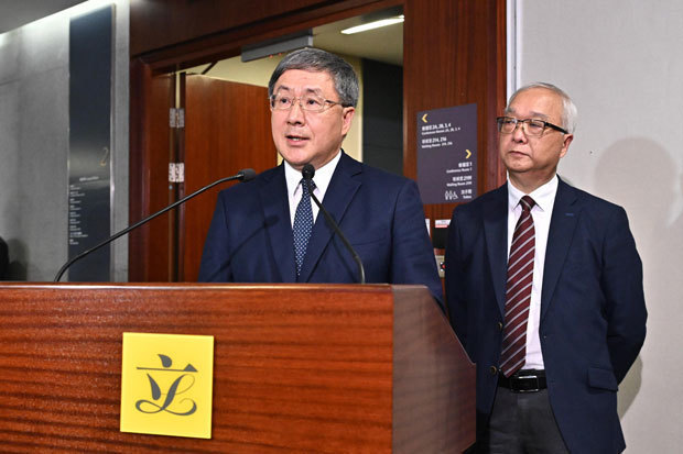 ごみ回収有料化の実施延期を表明した卓永興・政務副長官（左）と環境・生態局の謝展寰局長＝５月27日（香港政府提供）