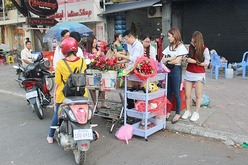 バレンタインデー前に路上の花屋に集まる人たち＝２月中旬、プノンペン（筆者撮影）