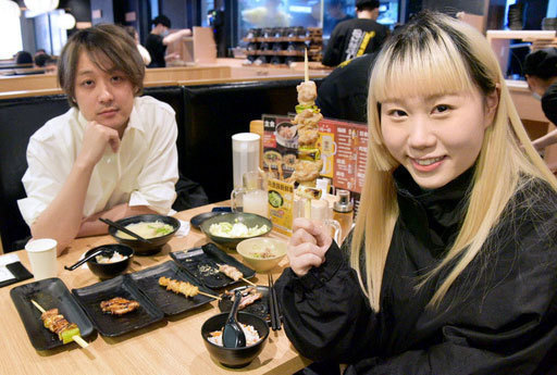 鳥貴族の中国大陸１号店で焼き鳥を楽しむ女性会社員（右）ら＝３月、中国上海市（共同）