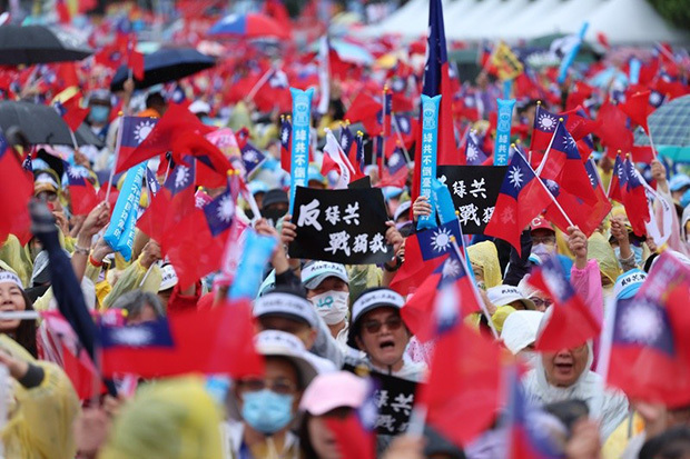 国民党が呼びかけた「反・頼政権」集会に参加し「独裁と戦おう」と書かれたプラカードを掲げる市民＝台北市の総統府前（中央通信社）