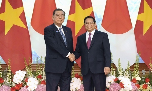 会談を前に、ベトナムのファム・ミン・チン首相（右）と握手する石破首相＝28日、ハノイ（共同）