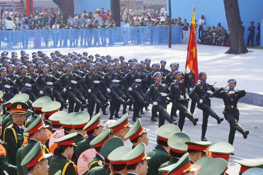 30日、ベトナム南部ホーチミンの記念式典で行進する軍兵士ら（共同）