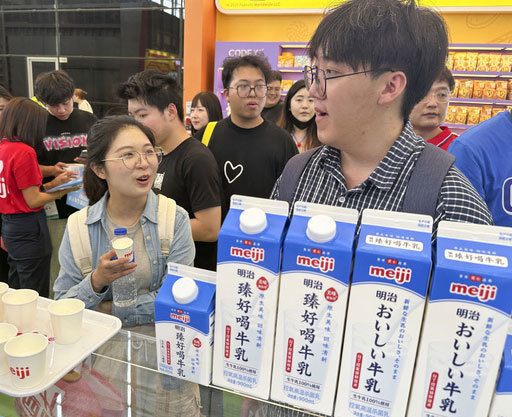 明治のブースで「おいしい牛乳」を試飲する中国人来場者＝５月19日、中国上海市（共同）