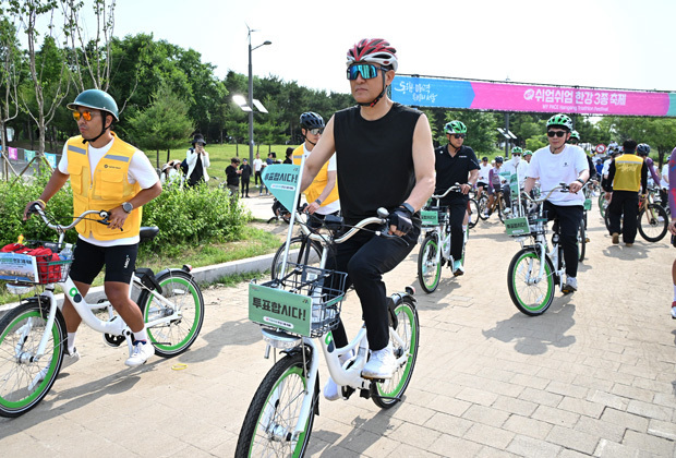 トライアスロンの自転車競技に参加する呉世勲市長（中央）。多くの市民と一緒に汗を流した＝（ソウル市提供）