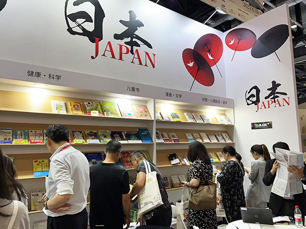 日本館ではジャンルごとに書籍を紹介するブースが設けられ、来場した中国人が熱心に手に取り見入っていた＝18日、北京市