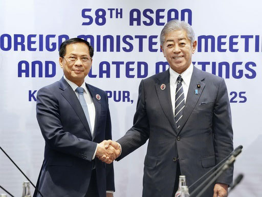 会談に先立ち握手を交わすベトナムのブイ・タイン・ソン副首相兼外相（左）と岩屋外相＝10日、クアラルンプール（共同）