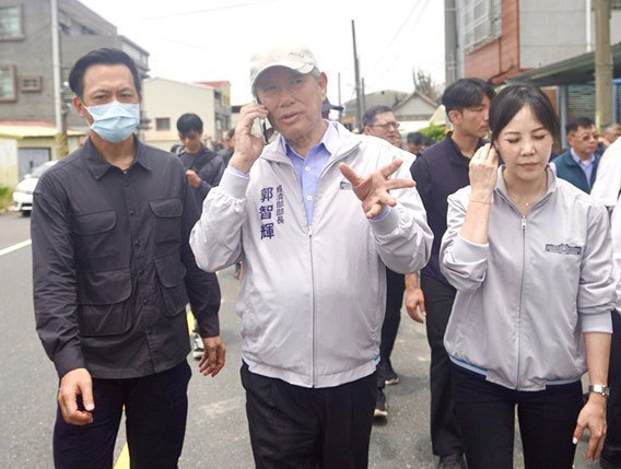 台湾経済部の郭智輝部長（手前中央）。写真は７月29日に台南市の一部地域の浸水被害を視察した際の様子（中央通信社）