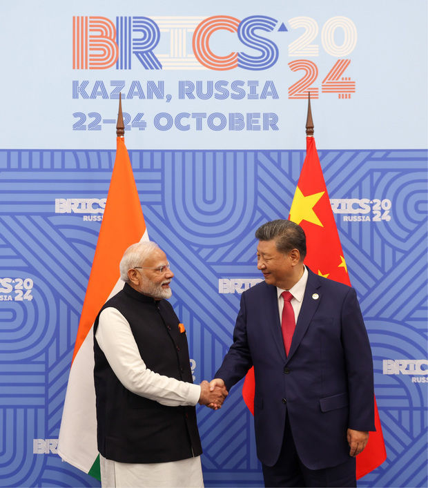 2024年10月にロシアで開かれたＢＲＩＣＳ首脳会議で握手する中国の習近平国家主席（右）とインドのモディ首相。インドはモーターに使われるレアアース磁石の８割以上を中国から輸入しているとされる（インド政府提供）