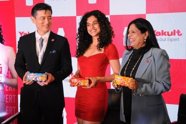 記念撮影に応じるインドヤクルト・ダノン社長の天野英治氏（左）、同社・学術責任者のニールジャ・ハジェラ氏（右）、新しいブランドアンバサダーのタープシー・パンヌ氏＝21日、インドの首都ニューデリー（ＮＮＡ撮影）