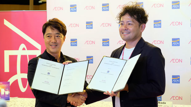 契約調印式で握手するイオンマレーシアの岡田社長（右）とイオンクレジットサービス（マレーシア）の前田社長＝19日、クアラルンプール（ＮＮＡ撮影）