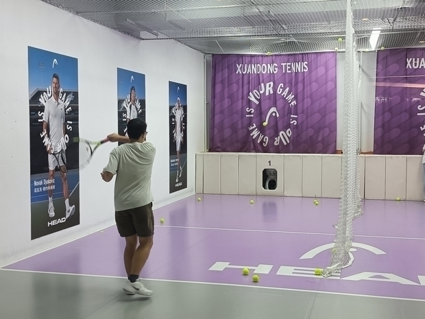 利用者は自動球出し機から発射されたボールを打ち返す＝上海市