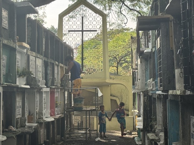 ウンダスを前に共同墓地で墓石などの清掃に余念がない市民＝28日、首都圏マカティ市（ＮＮＡ撮影）