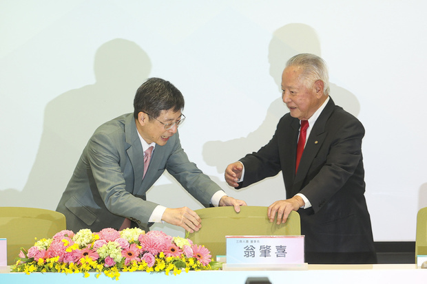 三商美邦人寿買収の記者会見で、同社の翁肇喜董事長（右）を席に案内する玉山金融グループの黄男州董事長＝５日夕（中央通信社）